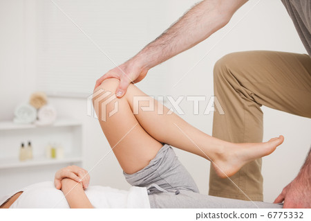 Osteopath working on a leg of a woman Osteopath working on a leg of a woman 6775332