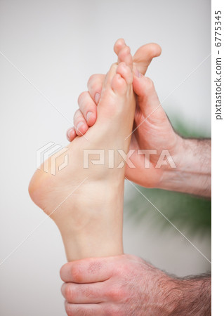 Doctor massaging the foot of his patient Doctor massaging the foot of his patient 6775345