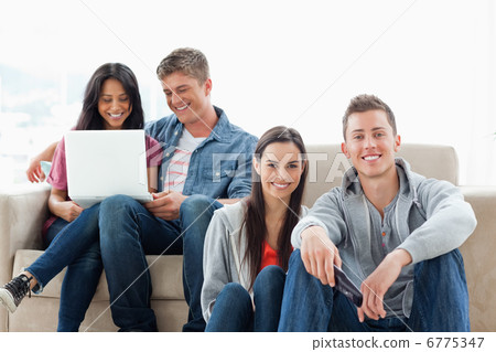 A man and woman sitting on the ground while another man and woma A man and woman sitting on the ground while another man and woma 6775347