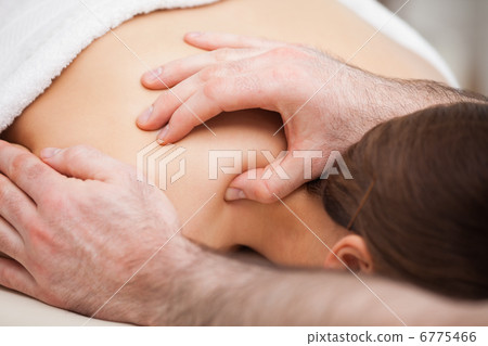 Osteopath massaging his patient while pressing his tumb 6775466