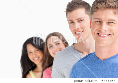 Four smiling people standing in front of one another at a slight 6775467