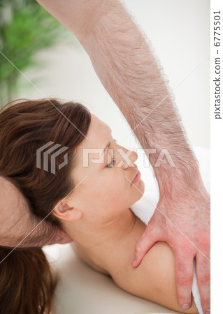 Therapist manipulating the neck of his patient while holding her 6775501