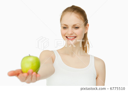 Cheerful woman presenting an apple 6775510