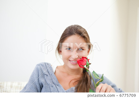Woman holding a rose while smiling Woman holding a rose while smiling 6775709