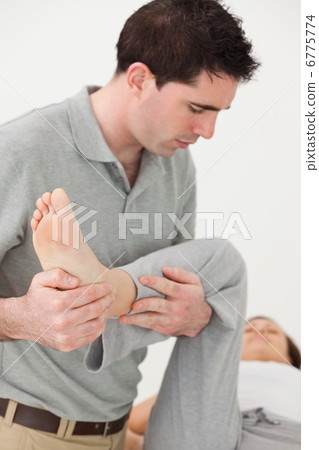 Woman lying on a table while being manipulated Woman lying on a table while being manipulated 6775774