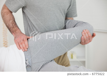 Chiropractor stretching the leg of a patient Chiropractor stretching the leg of a patient 6775822