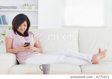 Woman smiling while looking at a phone Woman smiling while looking at a phone 6775831