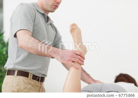 Woman lying while being stretched by a man Woman lying while being stretched by a man 6775866