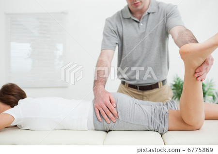 Woman lying while being stretched by a doctor 6775869