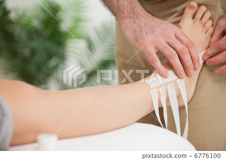 Doctor dressing an ankle Doctor dressing an ankle 6776100