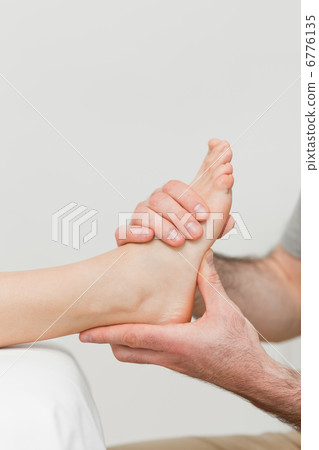 Hands of a physiotherapist massaging a foot Hands of a physiotherapist massaging a foot 6776135