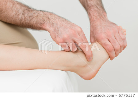Hands of a physiotherapist massaging the foot of a patient 6776137