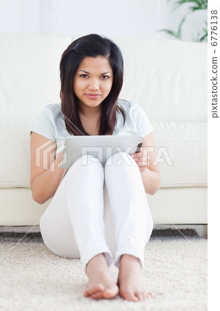 Woman on the floor while holding a tactile tablet Woman on the floor while holding a tactile tablet 6776138