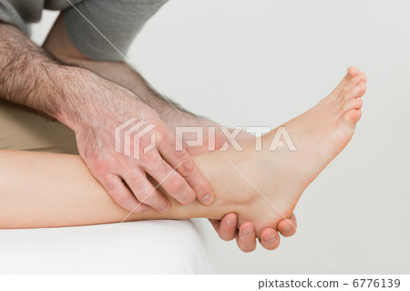 Physiotherapist working on the shin bone of a patient Physiotherapist working on the shin bone of a patient 6776139