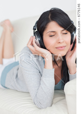 Woman closing her eyes while wearing headphones Woman closing her eyes while wearing headphones 6776146