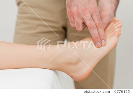 Fingers of a physiotherapist pressing on a foot Fingers of a physiotherapist pressing on a foot 6776155