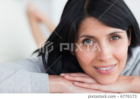 Woman smiling as she holds her head with her arms Woman smiling as she holds her head with her arms 6776173