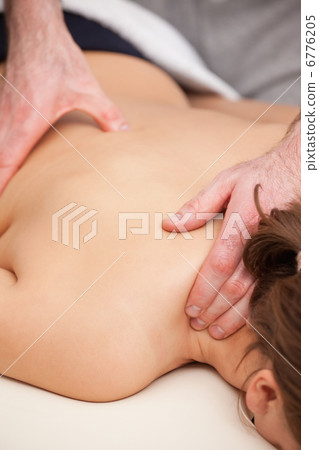 Doctor standing while massaging his patient Doctor standing while massaging his patient 6776205