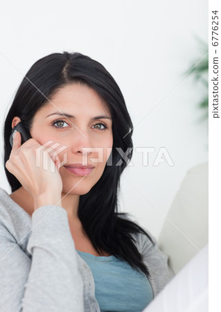 Woman phoning while resting on a couch Woman phoning while resting on a couch 6776254
