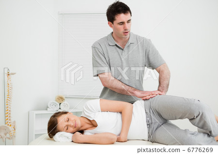 Doctor pressing his hands on the hip of his patient 6776269