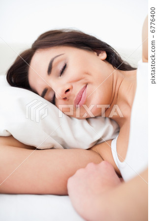 Calm brown-haired woman lying in her bed Calm brown-haired woman lying in her bed 6776400