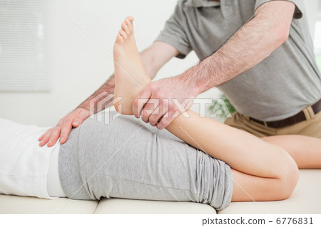 Close-up of a woman lying while being stretched Close-up of a woman lying while being stretched 6776831