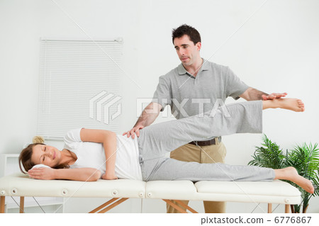 Physical therapist checking the pelvis of a woman 6776867