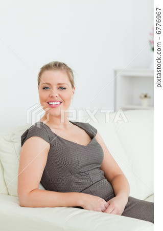 Woman smiling while sitting on a sofa 6776967