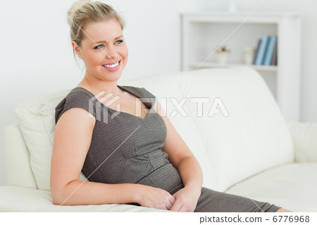 Pretty woman sitting on a sofa Pretty woman sitting on a sofa 6776968