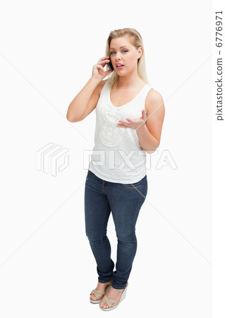 Serious blonde woman holding her mobile phone Serious blonde woman holding her mobile phone 6776971