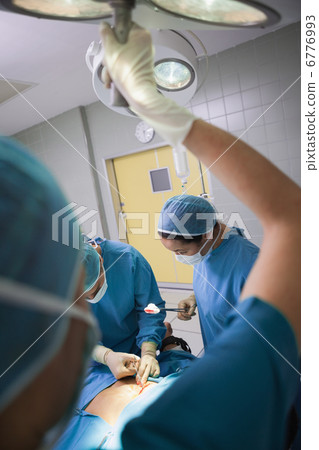Nurse illuminating the operating table Nurse illuminating the operating table 6776993
