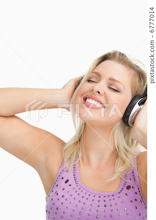 Blonde woman leaning her head while listening to music 6777014