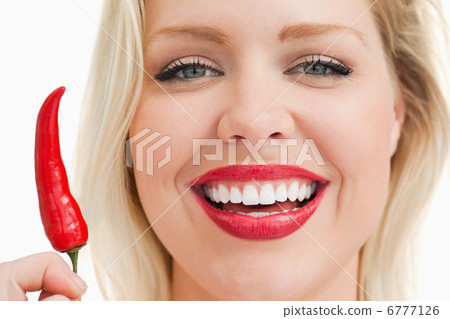 Happy blonde woman showing a chili Happy blonde woman showing a chili 6777126