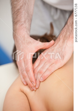 Doctor pressing the side of the back of his patient while standi Doctor pressing the side of the back of his patient while standi 6777138
