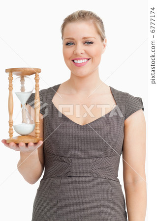 Woman smiling while holding a hourglass Woman smiling while holding a hourglass 6777174