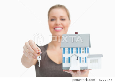Woman blurred showing a model house and a key Woman blurred showing a model house and a key 6777255
