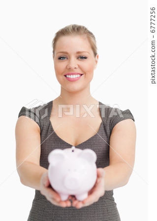Piggy bank showing by a pretty woman Piggy bank showing by a pretty woman 6777256