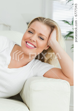 Woman lying on a sofa with a hand in her hair Woman lying on a sofa with a hand in her hair 6777343