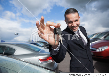 Happy dealer holding car keys 6777374