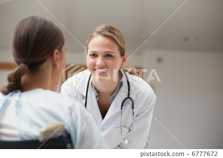Smiling doctor looking at a patient on a wheelchair Smiling doctor looking at a patient on a wheelchair 6777672