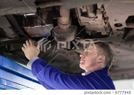 Mechanic repairing the below of a car Mechanic repairing the below of a car 6777948