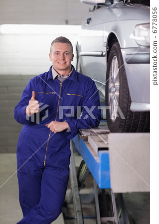 Man standing next to a car with his thumb up Man standing next to a car with his thumb up 6778056