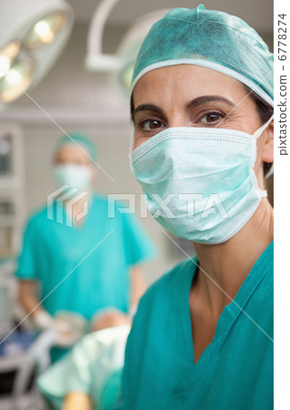 Smiling surgeon standing in front of a colleague Smiling surgeon standing in front of a colleague 6778274
