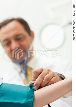 Doctor placing his stethoscope on the arm of his patient Doctor placing his stethoscope on the arm of his patient 6778405
