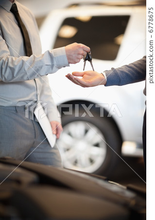 Salesman handing keys to a customer 6778675