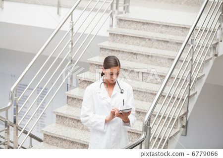Doctor using a tablet computer on stairs 6779066