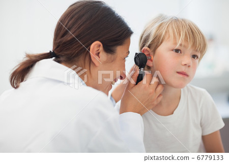 Stock Photo: Doctor auscultating the ear of a child