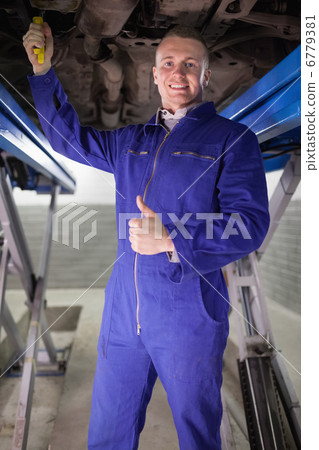 Man repairing a car with his thumb up Man repairing a car with his thumb up 6779381
