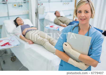 Nurse standing next to transfused patients 6779407