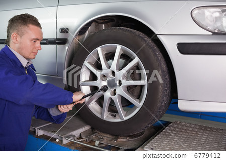 Mechanic unscrewing a bolt Mechanic unscrewing a bolt 6779412